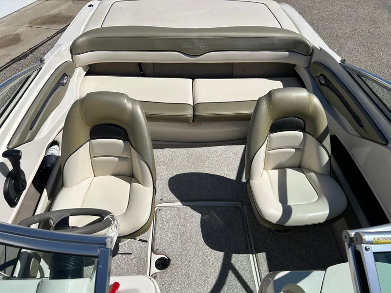 Slide: The Image of 2005 Sea Ray 200SP boat interior with beige seating and steering wheel. - 2