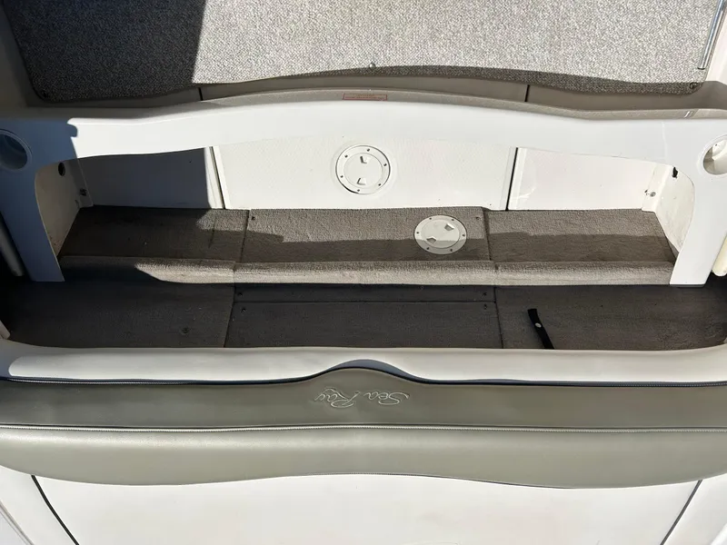 Slide: The Image of 2005 Sea Ray 200SP boat interior with storage compartment and cushioned seating. - 20