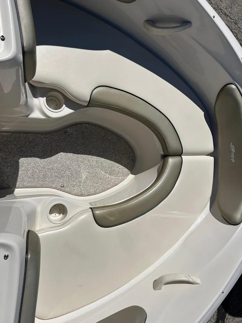 Slide: The Image of 2005 Sea Ray 200SP boat interior with cushioned seating and cup holders. - 30