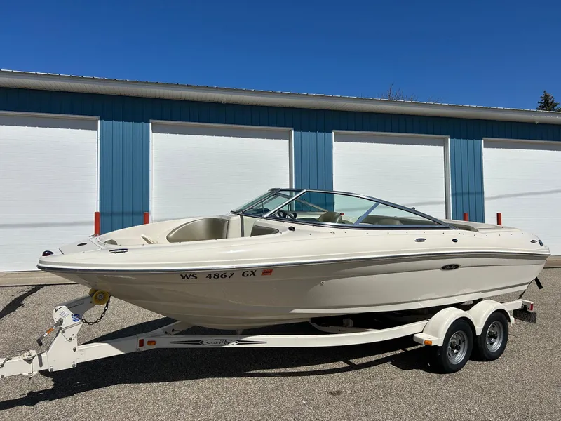 Slide: The Image of 2005 Sea Ray 200SP boat on trailer, parked outside blue and white storage units. - 37