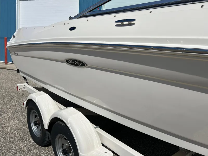 Slide: The Image of 2005 Sea Ray 200SP boat on trailer, white exterior, parked outdoors. - 8