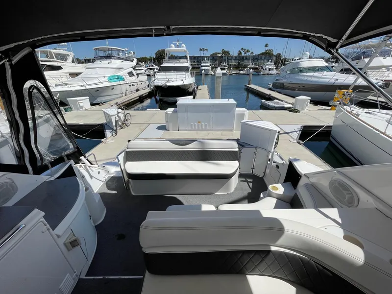Slide: The Image of 2005 Regal 4260 COMMODORE yacht interior at marina, featuring seating and docked boats. - 17