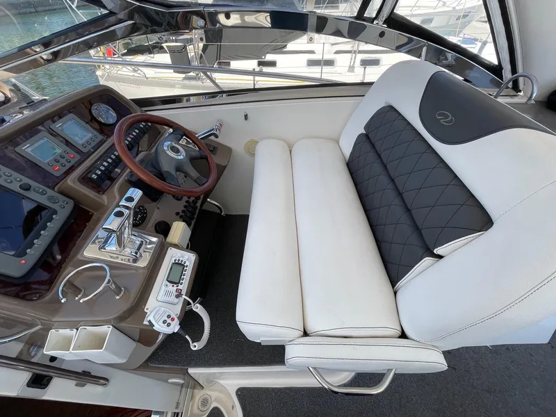 Slide: The Image of 2005 Regal 4260 COMMODORE helm with white seating and modern controls. - 23