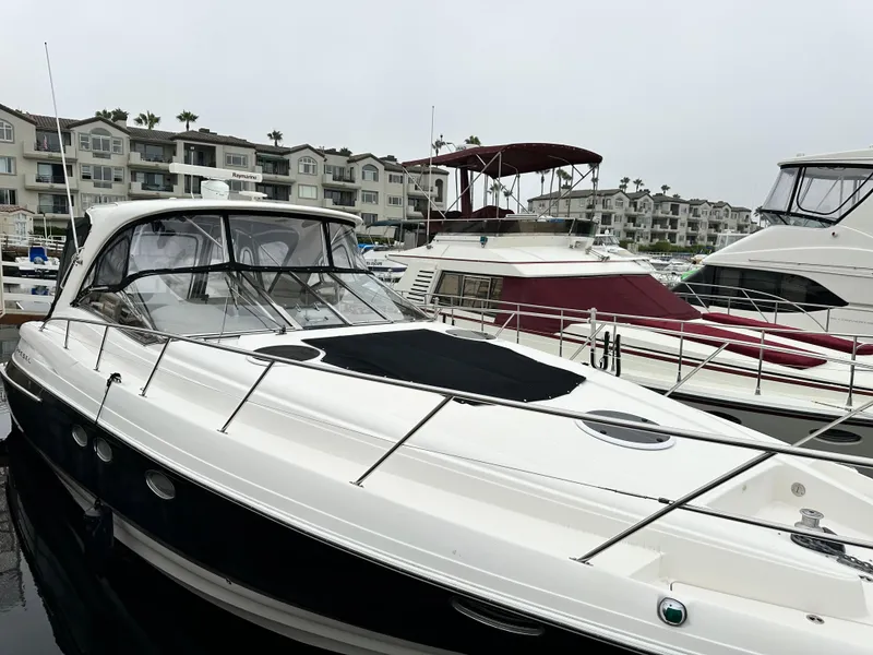Slide: The Image of 2005 Regal 4260 Commodore yacht docked in marina, surrounded by other boats and waterfront buildings. - 3