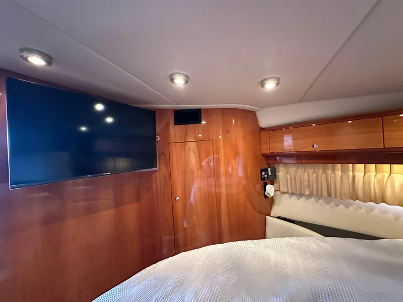 Slide: The Image of Luxurious cabin interior of 2005 Regal 4260 COMMODORE yacht with TV and wood paneling. - 43