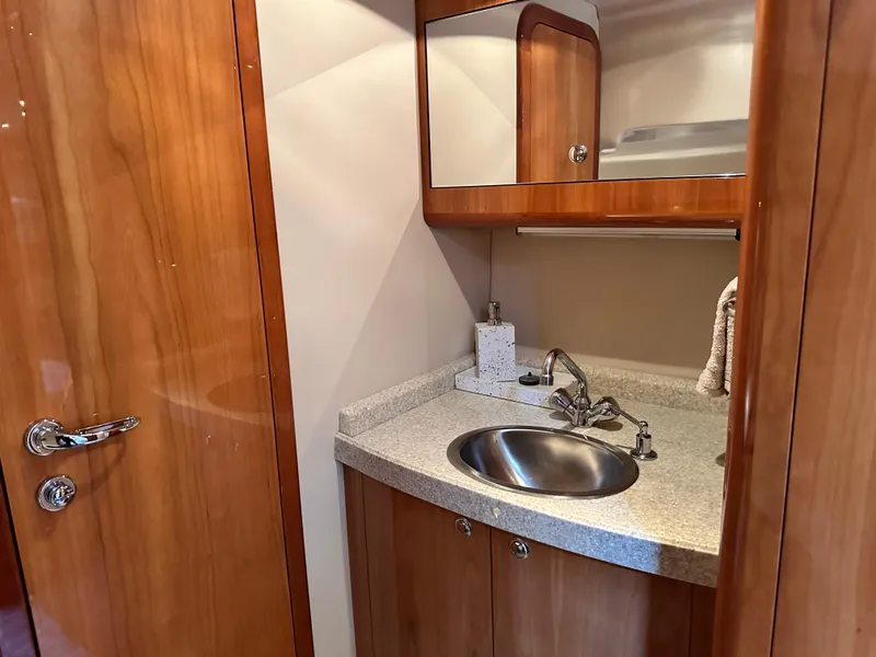Slide: The Image of 2005 Regal 4260 COMMODORE yacht bathroom with wooden cabinetry and stainless steel sink. - 45