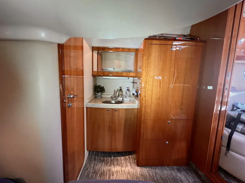 Slide: The Image of 2005 Regal 4260 COMMODORE yacht interior with wooden cabinetry and compact kitchenette. - 48