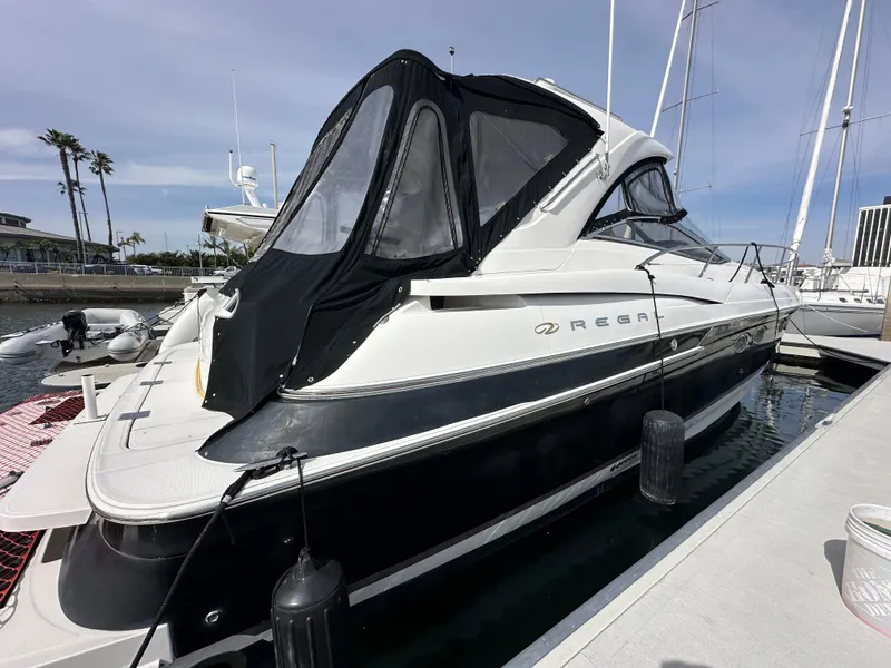Slide: The Image of 2005 Regal 4260 Commodore yacht docked at marina with black canopy. - 5