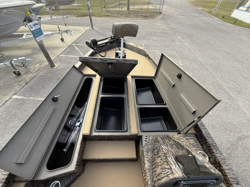 Slide: The Image of 2025 Xpress Hyper-Lift Bass Series boat with open storage compartments in a sales lot. - 5