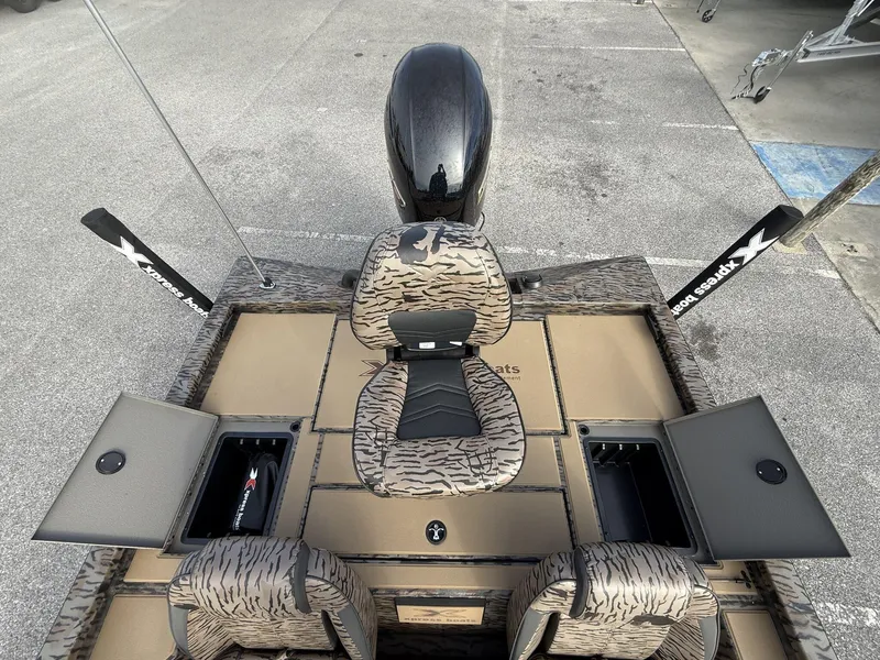 Slide: The Image of 2025 Xpress Hyper-Lift Bass Series boat interior with camo seats and storage compartments. - 6