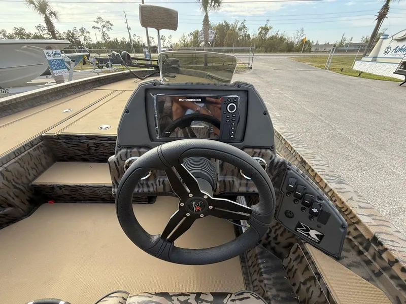 Slide: The Image of 2025 Xpress Hyper-Lift Bass Series boat dashboard with steering wheel and control panel. - 8