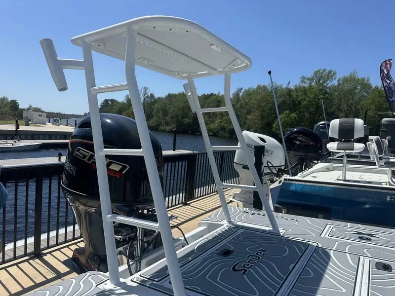 Slide: The Image of 2025 Xpress Skiff 185 boat with outboard motor, docked by a scenic river. - 12