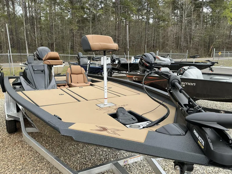Slide: The Image of 2025 Xpress Hyper-Lift Bass Series boat with tan seating and Minn Kota trolling motor. - 2