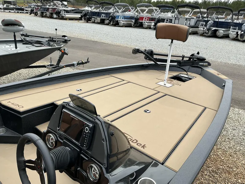 Slide: The Image of 2025 Xpress Hyper-Lift Bass Series boat with advanced dashboard and seating, parked among other boats. - 7