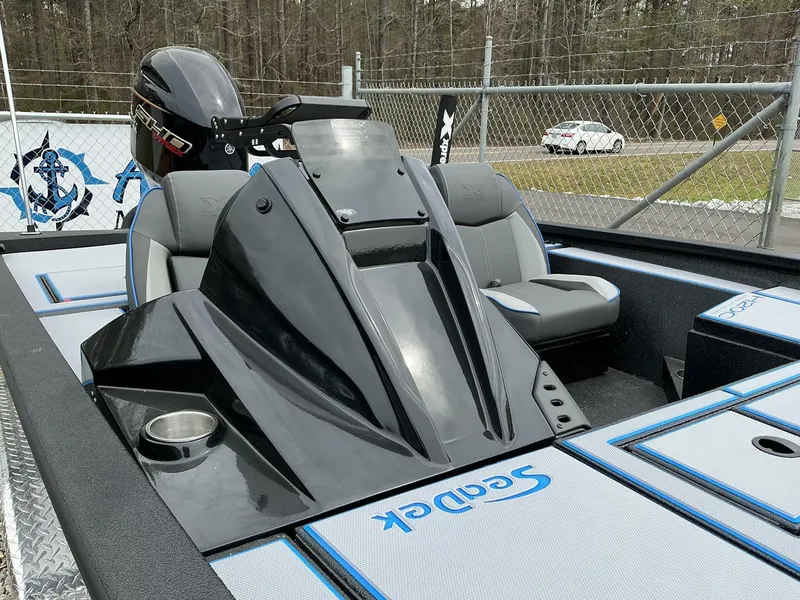 Slide: The Image of 2025 Xpress Hyper-Lift Crappie Series H20 boat interior with seating and motor, parked outdoors. - 4