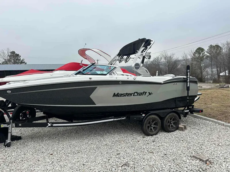 Slide: The Image of 2020 MasterCraft XStar boat on trailer, parked on gravel, overcast sky. - 1
