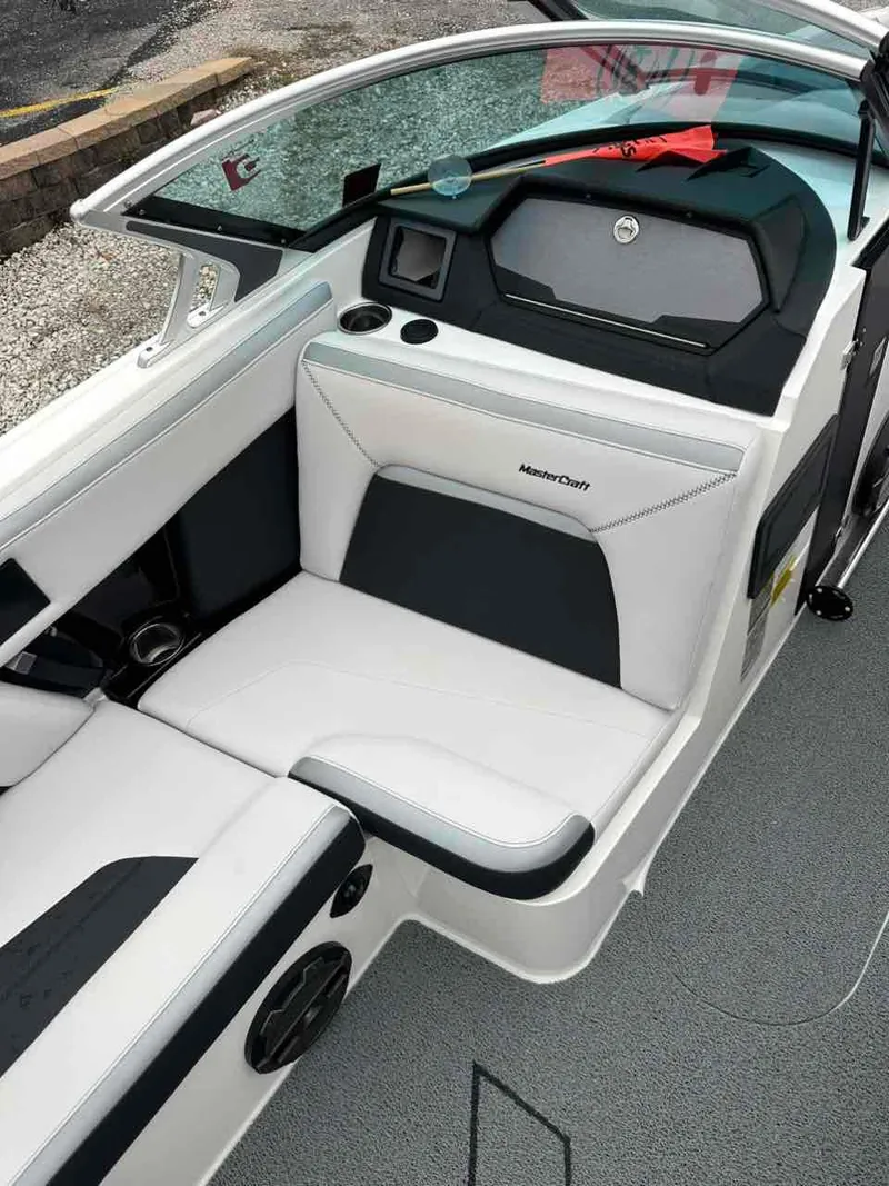 Slide: The Image of 2020 MasterCraft XStar boat interior with white and black seating, cup holders, and dashboard. - 7