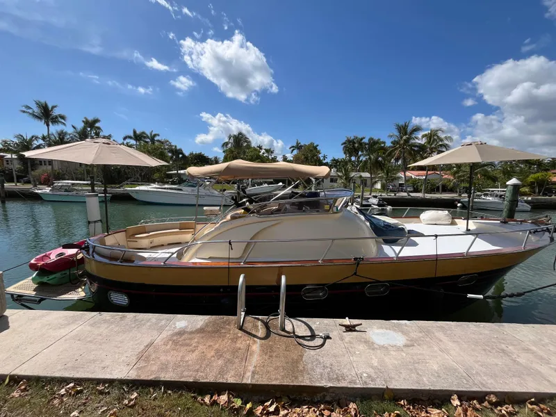 Slide: The Image of 2005 Apreamare Don Giovanni yacht docked by a sunny waterfront with palm trees. - 3