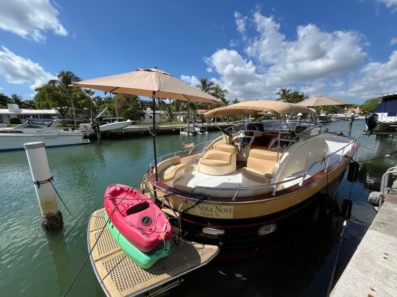Slide: The Image of 2005 Apreamare Don Giovanni yacht docked with kayaks and umbrellas, under a sunny sky. - 9