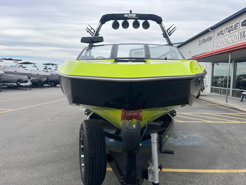 Slide: The Image of 2023 Axis T220 boat in vibrant green on trailer at dealership. - 11