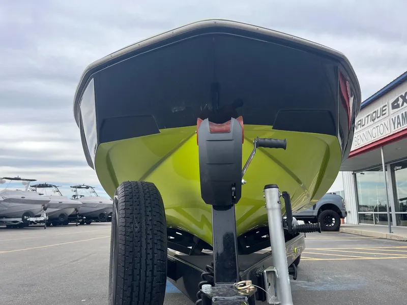 Slide: The Image of 2023 Axis T220 boat on trailer, vibrant green hull, parked at dealership. - 12