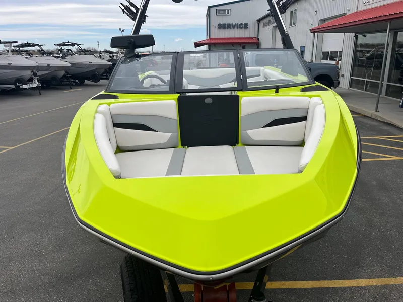 Slide: The Image of 2023 Axis T220 boat with vibrant lime green exterior and white interior, parked at dealership. - 13
