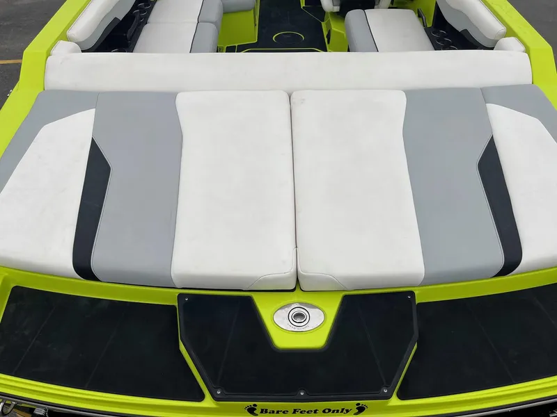 Slide: The Image of 2023 Axis T220 boat with gray and white seating, lime green accents, "Bare Feet Only" text. - 16