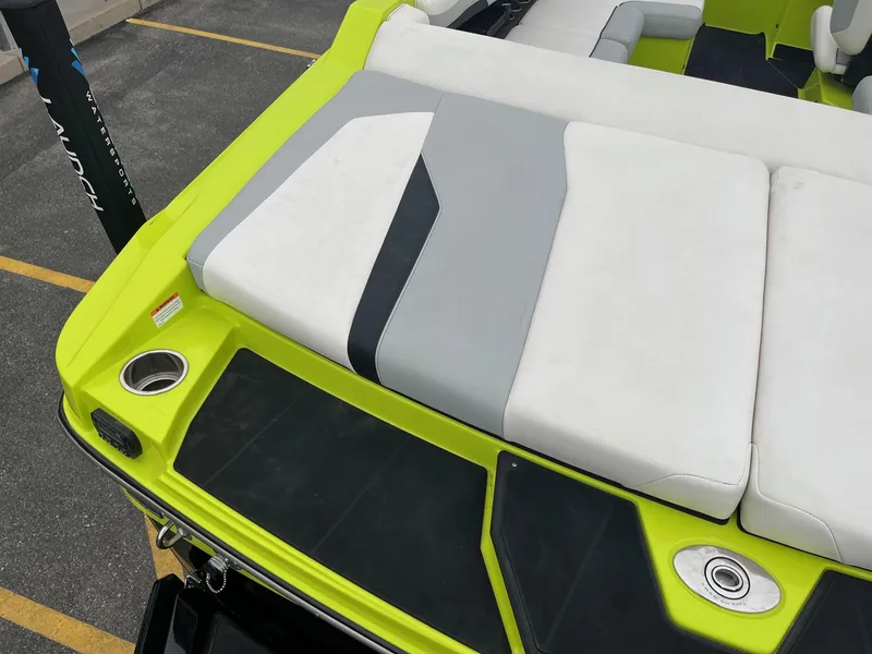 Slide: The Image of 2023 Axis T220 boat with lime green and gray seating, featuring cup holders and sleek design. - 17