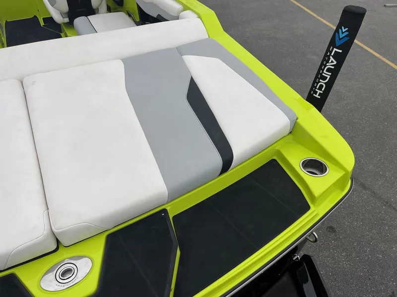 Slide: The Image of 2023 Axis T220 boat with lime green deck and cushioned seating. - 18