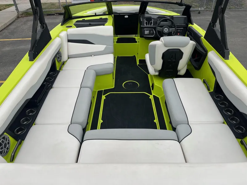 Slide: The Image of 2023 Axis T220 boat interior with white and lime green seating, modern dashboard, and cup holders. - 19
