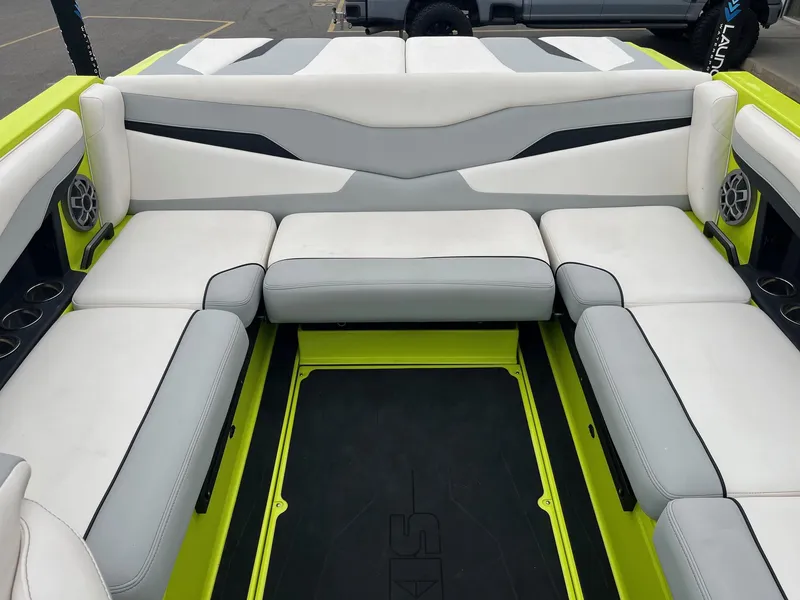 Slide: The Image of 2023 Axis T220 boat interior with white and gray seating, lime green accents, and cup holders. - 20