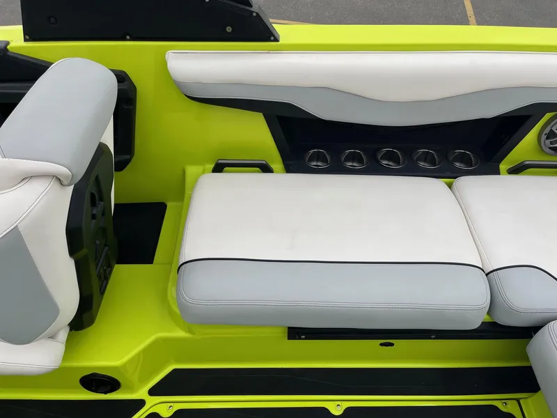 Slide: The Image of 2023 Axis T220 boat interior with lime green and white seating, featuring cup holders. - 21