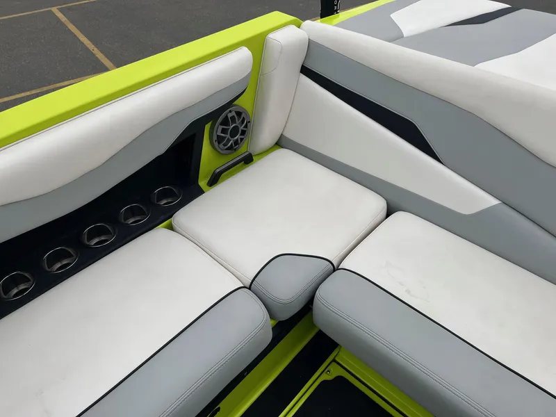 Slide: The Image of 2023 Axis T220 boat interior with white and gray seating, cup holders, and speaker. - 22