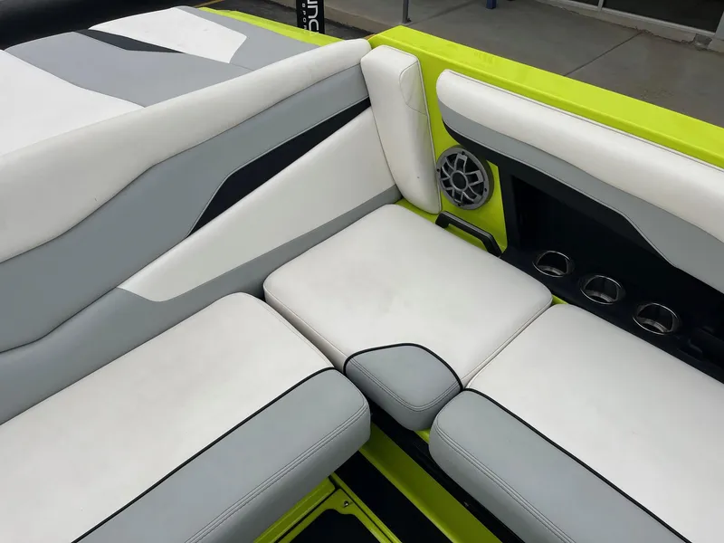 Slide: The Image of 2023 Axis T220 boat interior with white and gray seating, cup holders, and speaker. - 24