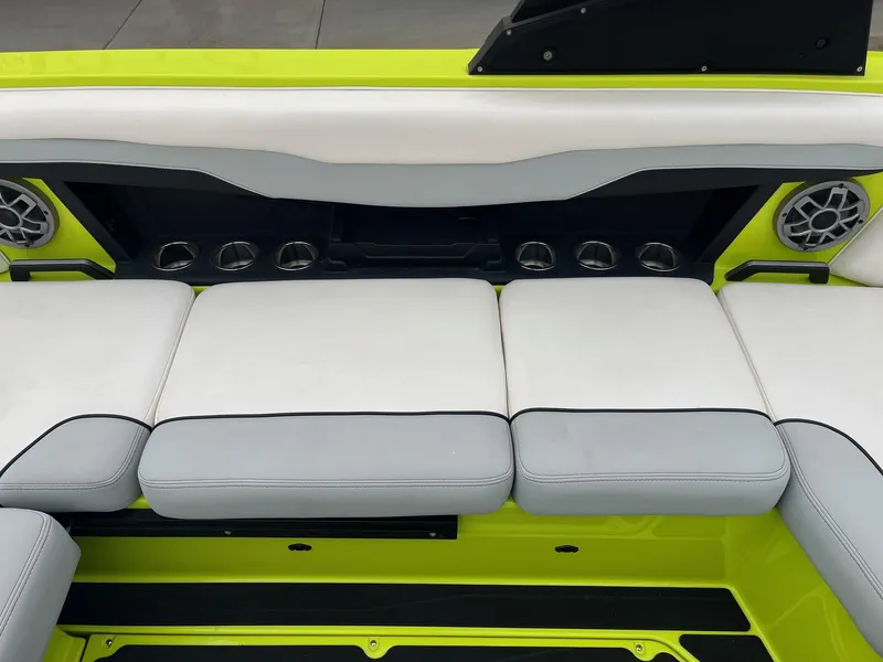 Slide: The Image of 2023 Axis T220 boat interior with white and gray seating, lime green accents, and built-in speakers. - 25