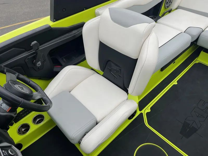 Slide: The Image of 2023 Axis T220 boat interior with white and gray seating, lime green accents, and steering wheel. - 28