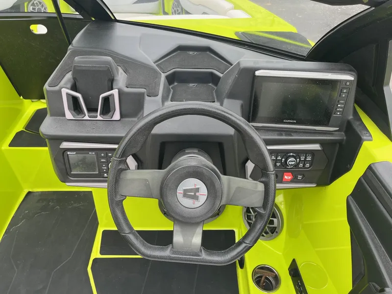 Slide: The Image of 2023 Axis T220 boat dashboard with steering wheel and Garmin display, vibrant yellow interior. - 29