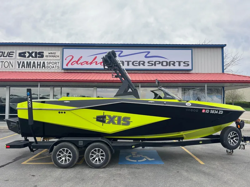 Slide: The Image of 2023 Axis T220 boat in vibrant yellow and black, parked at Idaho Water Sports. - 3