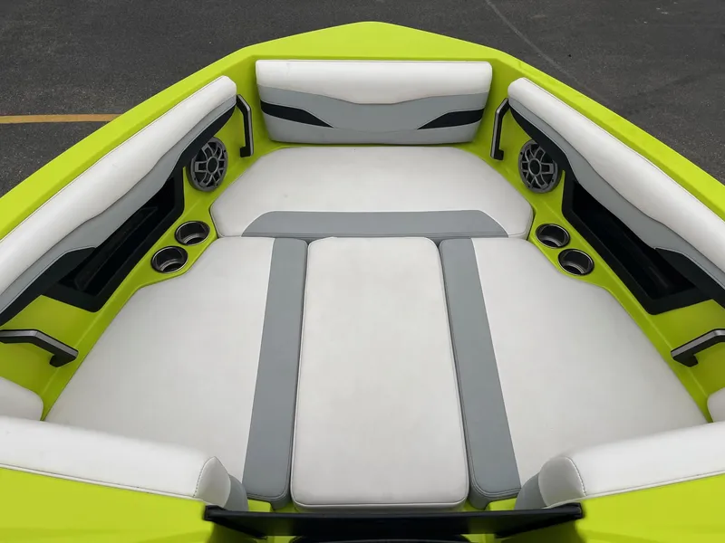 Slide: The Image of 2023 Axis T220 boat interior with lime green and white seating, cup holders, and speakers. - 31