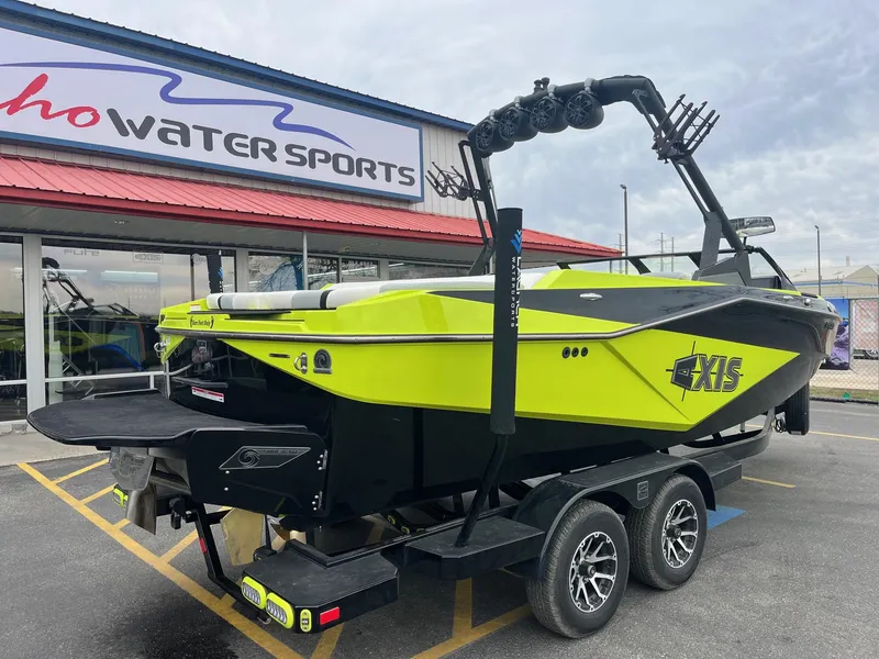 Slide: The Image of 2023 Axis T220 boat in bright yellow at a water sports dealership. - 4
