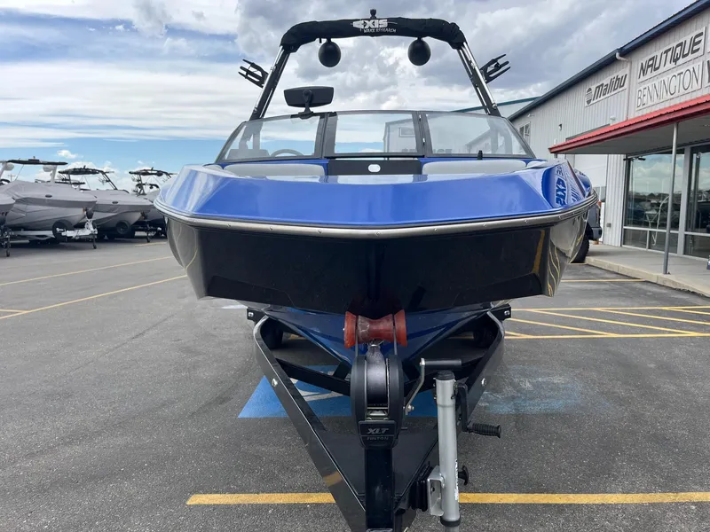 Slide: The Image of 2023 Axis T220 boat in blue, parked at a dealership with other boats visible. - 10