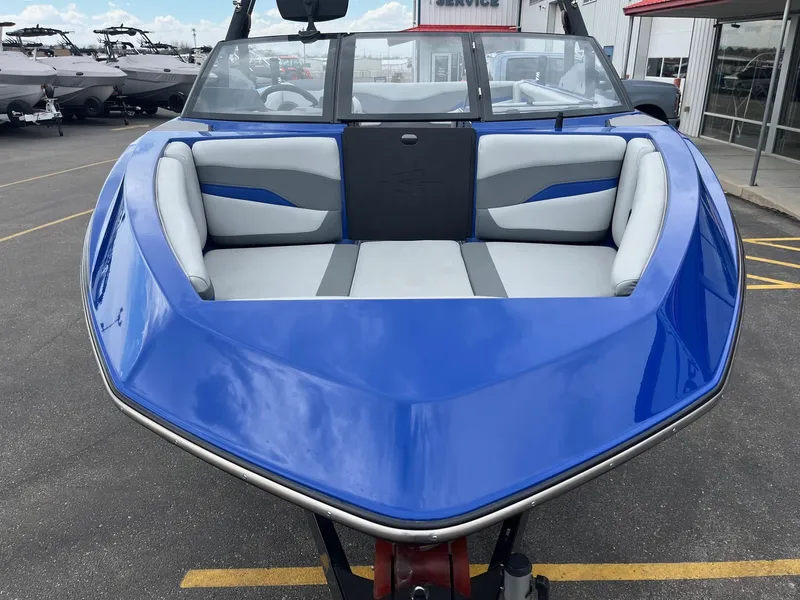 Slide: The Image of 2023 Axis T220 boat with blue exterior and spacious seating, parked outdoors. - 12