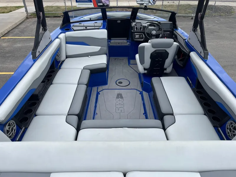 Slide: The Image of 2023 Axis T220 boat interior with blue and gray seating, modern dashboard, and spacious layout. - 18