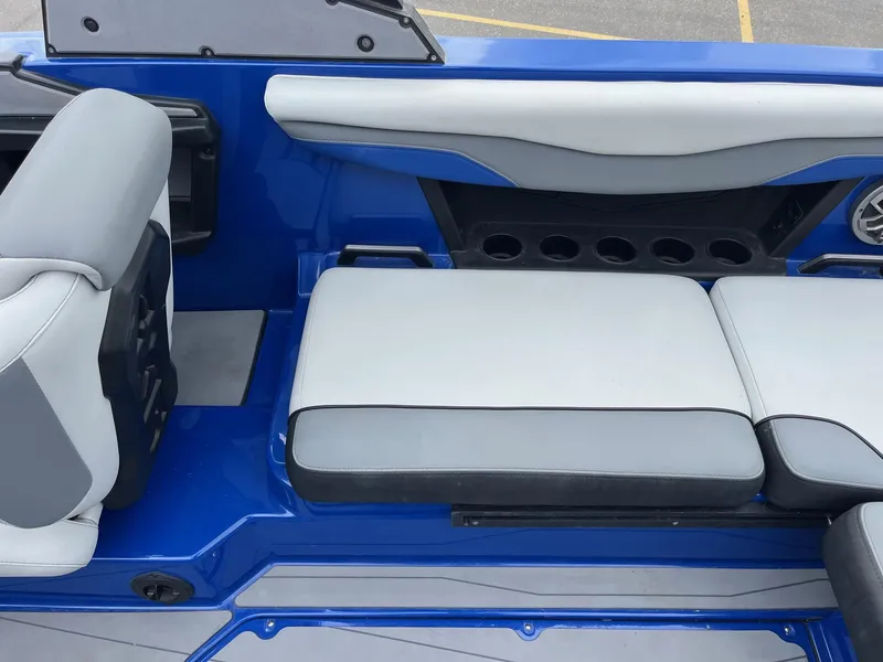 Slide: The Image of 2023 Axis T220 boat interior with blue and gray seating and cup holders. - 20