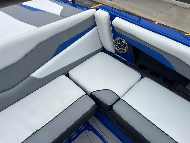 Slide: The Image of 2023 Axis T220 boat interior with gray and white cushioned seating and speaker. - 23