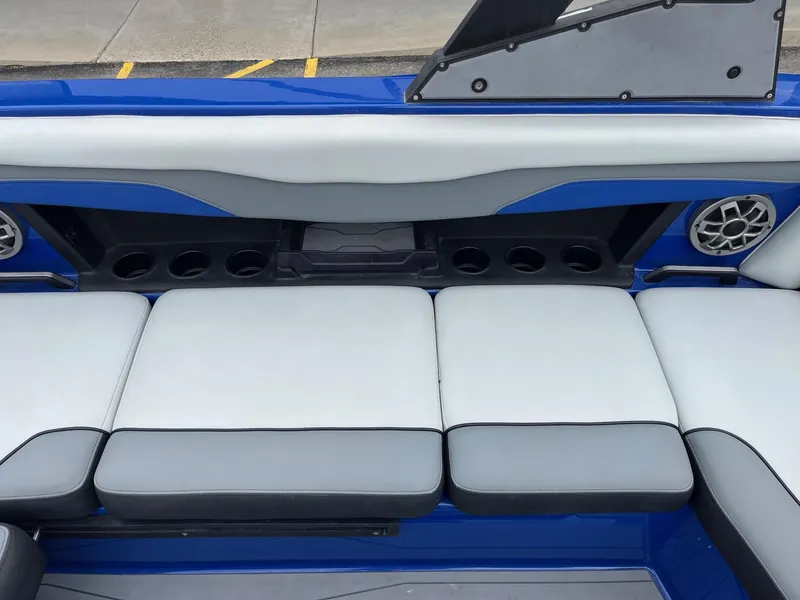 Slide: The Image of 2023 Axis T220 boat interior with blue and gray seating, cup holders, and speaker. - 24