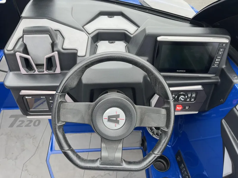 Slide: The Image of 2023 Axis T220 boat dashboard with steering wheel and Garmin display. - 28