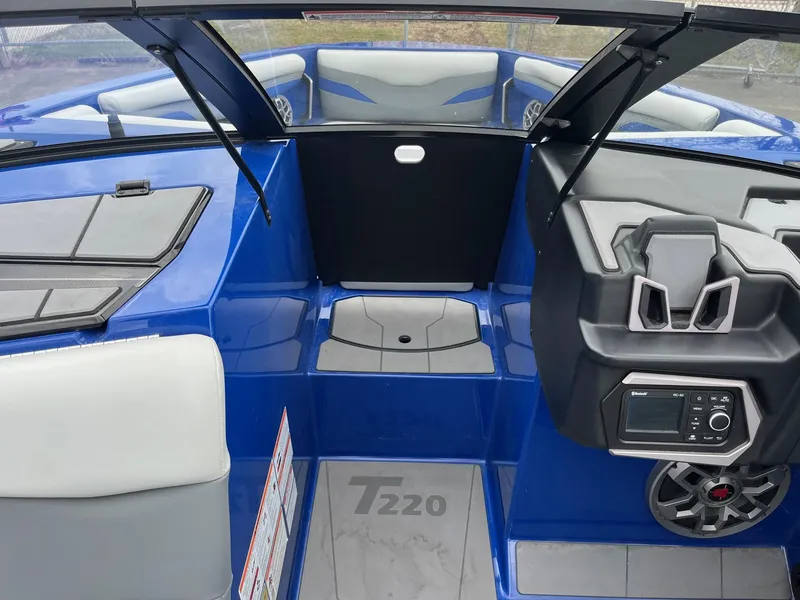 Slide: The Image of 2023 Axis T220 boat interior with blue and gray seating, dashboard, and speaker system. - 29
