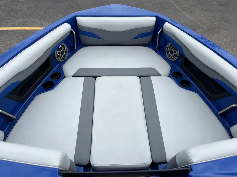 Slide: The Image of 2023 Axis T220 boat interior with blue and gray seating, cup holders, and speakers. - 30