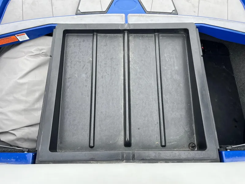 Slide: The Image of 2023 Axis T220 boat storage compartment with black cover and blue trim. - 34